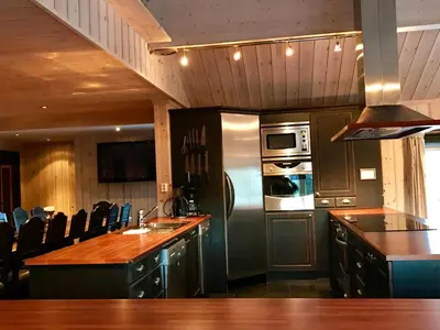 a kitchen with a stainless steel refrigerator and a counter at Kirkebøen Hytter in Hemsedal