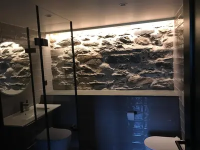 a bathroom with a painting on the wall above a toilet at Godo Lodge in Godøy