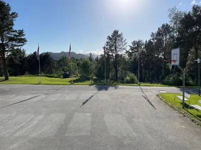 an empty basketball court with flags and a basketball hoop at BORG Sommerhotell in Ålesund