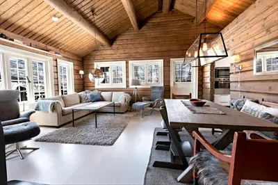 a living room with a wooden ceiling and a table at Utsikten in Sykkylven