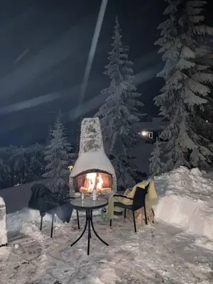 a snow covered yard with a table and a fireplace at Large cabin at Sjusjøen with sauna, fireplace, view and cross-country skiing in Ringsaker