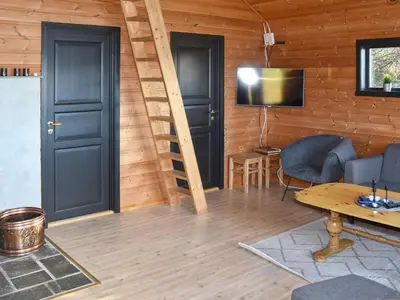a living room with two black doors and a television at 6 person holiday home in Bud-By Traum in Bud
