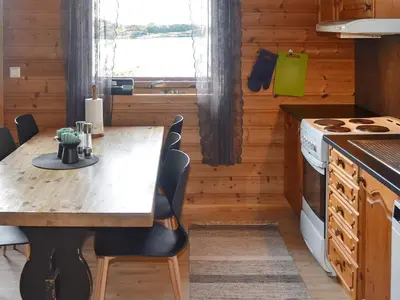 a kitchen with a table and chairs in a room at 6 person holiday home in Bud-By Traum in Bud