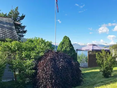 a yard with bushes and an american flag at 6 person holiday home in Utvik in Utvik