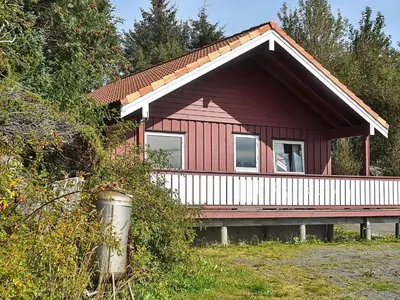 a red house with a bench in front of it at 6 person holiday home in Bud-By Traum in Bud