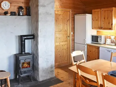 a wood stove in a kitchen with a table at 6 person holiday home in Bud-By Traum in Bud