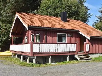 a small red house with a white porch at 6 person holiday home in Bud-By Traum in Bud