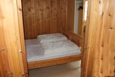 a small wooden bed in a wooden room at Kvitfjell Alpinhytter Kvitfjellvegen 492 in Kvitfjell