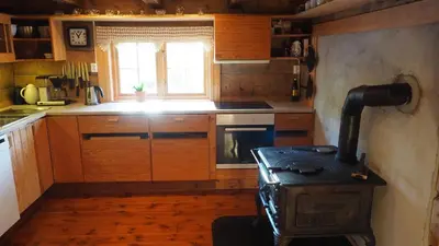 a kitchen with an old stove in a room at Klævold utleigehytte in Klevoll