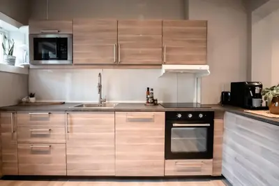 a kitchen with wooden cabinets and a sink at Trolltunga Living in Tysso