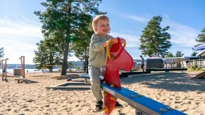 a young boy playing on a slide at a playground at Topcamp Onsakervika - Tyrifjorden in Svensrud