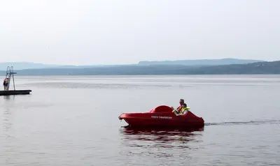 a person in a red boat in the water at Topcamp Onsakervika - Tyrifjorden in Svensrud