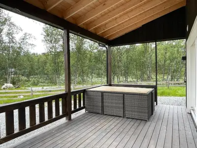a screened porch with a table on a wooden deck at Sigurdhytta in Ål