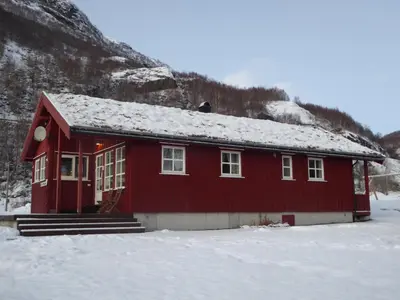 a red house with snow on the roof in the snow at Seim Camping - Røldal in Røldal