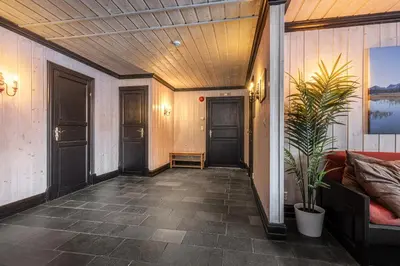 a hallway with a couch and a potted plant at Tinden Apartments in Hemsedal