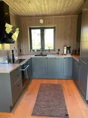 a large kitchen with blue cabinets and a window at Geilo - Ny og flott hytte på budalstølen in Geilo