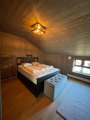 a bedroom with a bed and a stool in a room at Geilo - Ny og flott hytte på budalstølen in Geilo