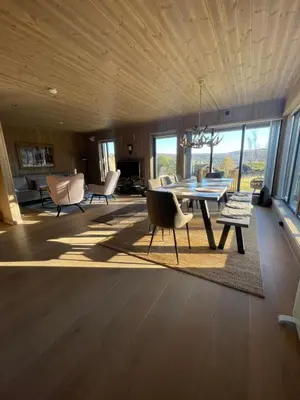a living room with a dining room table and chairs at Geilo - Ny og flott hytte på budalstølen in Geilo