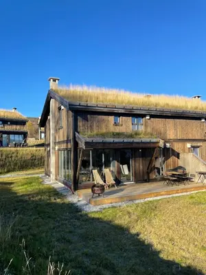 a house with a grass roof with a deck at Geilo - Ny og flott hytte på budalstølen in Geilo