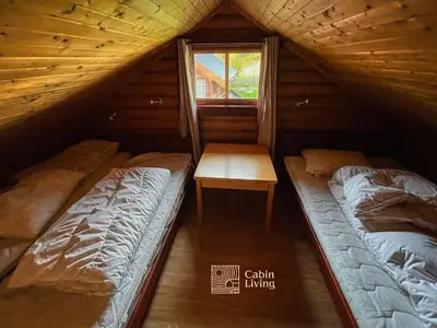 two beds in a room with a window at Cozy cottage in central Beitostølen with Sauna in Beitostøl