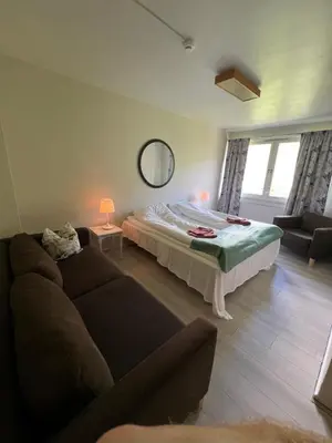 a living room with a bed and a couch at Hallingskarvet Fjellstue as in Hovet