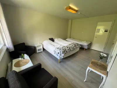 a small room with two beds and a couch at Hallingskarvet Fjellstue as in Hovet