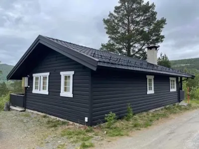 a black house with a chimney on top of it at Uvdalhytta - close to cross country and downhill skiing in Uvdal