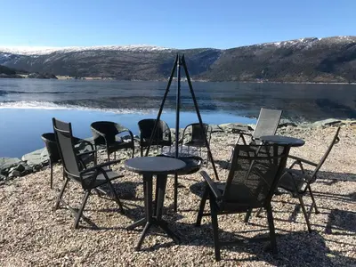 a group of chairs and a table on a beach at Seaside 3-bedroom House in Svelgen