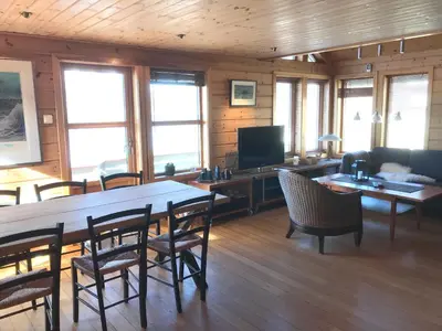 a living room with a table and chairs and a television at Seaside 3-bedroom House in Svelgen