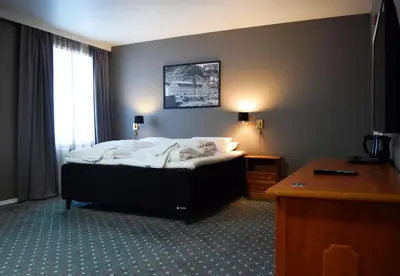 a hotel room with a bed and a desk at Rjukan Hotell in Rjukan