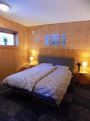 a bedroom with a large bed with two tables at Kråkehaugen Feriehus, a perfect holiday retreat near Åheim in Åheim