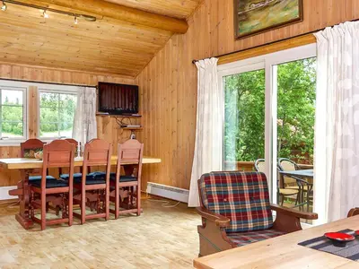a dining room with a table and chairs and windows at 7 person holiday home in Hemsedal-By Traum in Hemsedal