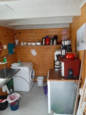 a small kitchen with a sink and a washing machine at Kvamshaugen hytter in Luster