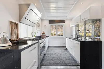 a kitchen with white cabinets and black counter tops at Solsiden - in the center of Geilo in Geilo