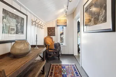 a hallway with a table and a vase on the floor at Solsiden - in the center of Geilo in Geilo