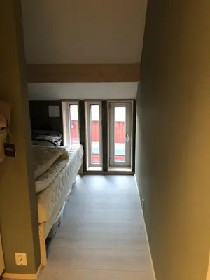 a bedroom with a bed and sliding glass doors at Robinsons Rorbu - located in Bud in Bud