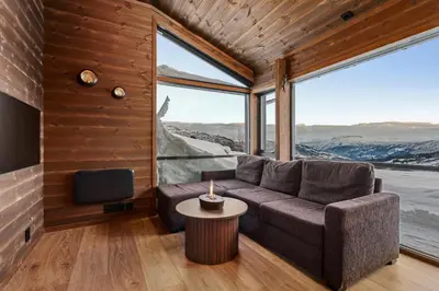 a living room with a couch and a table at Ski in ski out mountain cabin with views and extra unit option in Sogndal