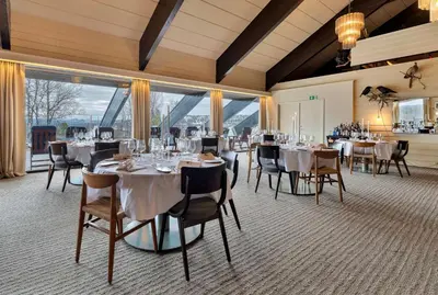 a dining room with tables and chairs and large windows at Ranten Hotell Best Western Signature Collection in Nesbyen