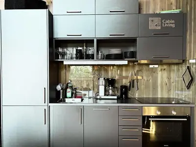 a kitchen with stainless steel cabinets and a stove at Cozy Apartment electric car charger & ski in out Sjusjøen in Sjusjøen