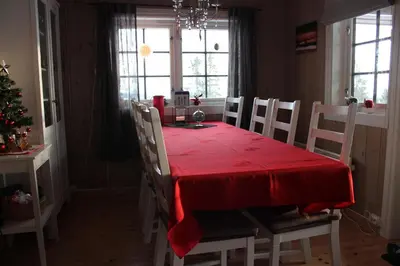 a dining room with a red table and chairs at Hytte sentralt Ljøsheim, Ringsaker(nær Sjusjøen) in Ringsaker