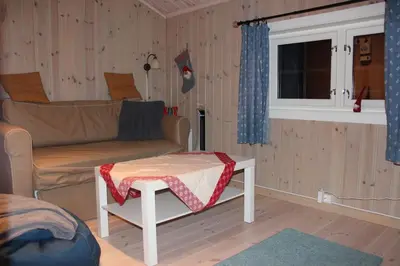 a living room with a couch and a table at Hytte sentralt Ljøsheim, Ringsaker(nær Sjusjøen) in Ringsaker