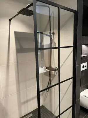 a shower with a glass door in a bathroom at Olden apartments 2 in Stryn