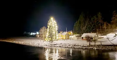 a christmas tree is lit up in a village at night at Voss/Bolstad: Peaceful countryside cabin/lodge in Bolstadøyri
