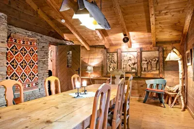 a dining room with a wooden table and chairs at Voss/Bolstad: Peaceful countryside cabin/lodge in Bolstadøyri