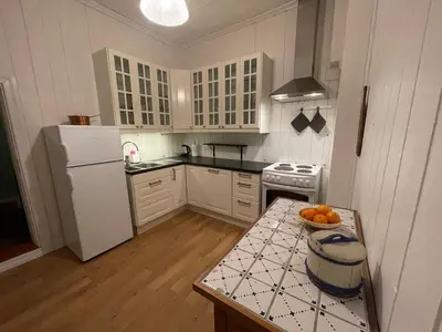 a kitchen with a white refrigerator and a bowl of oranges on a counter at Finnegården Røros in Røros