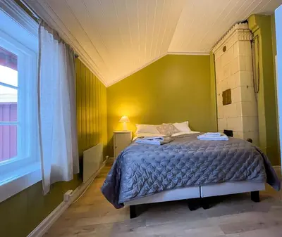 a bedroom with a bed in a green room at Finnegården Røros in Røros