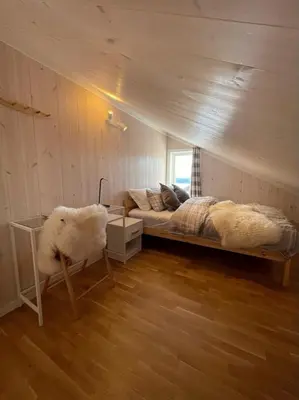 a bedroom with a bed and a chair in it at Skarvebo - cabin with amazing view in Hol