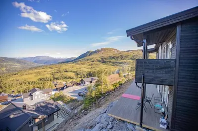 a view of a house with mountains in the background at Panorama 17 - fantastisk utsikt! in Sogndal