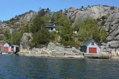 a group of houses on the shore of the water at Bergen/Sotra:Waterfront cabin(s).Boat.Fish.Jacuzzi in Haganes