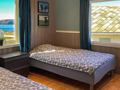 a bedroom with two beds in front of a window at 5 person holiday home in Svelgen-By Traum in Svelgen